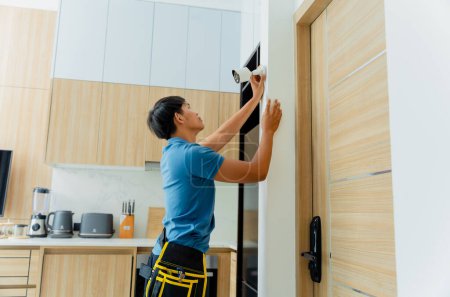 Photo for A technician installs a CCTV camera in a modern apartment - Royalty Free Image