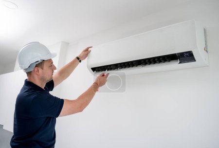 Foto de Técnico limpia el sistema de aire acondicionado en un apartamento moderno - Imagen libre de derechos