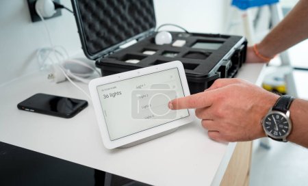 Foto de Un técnico trabaja con un kit de demostración del sistema de hogar inteligente. - Imagen libre de derechos