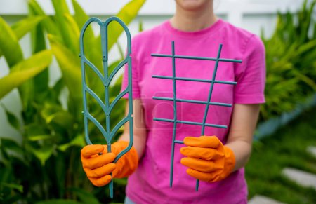 Photo for A young woman takes care of the garden and tying up plants. - Royalty Free Image