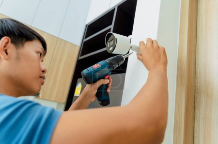 Photo for A technician installs a CCTV camera in a modern apartment - Royalty Free Image