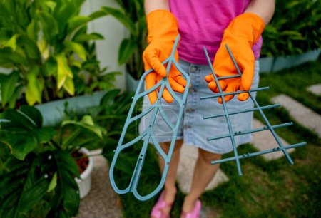 Téléchargez les photos : Une jeune femme s'occupe du jardin et attache les plantes. - en image libre de droit