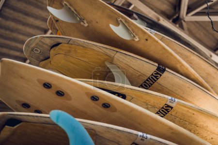 A variety of surfboards are neatly displayed on a stand.