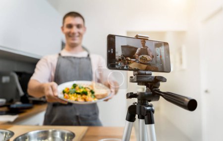 Foto de El chef está emitiendo en vivo desde el taller cómo preparar una comida vegetariana. - Imagen libre de derechos