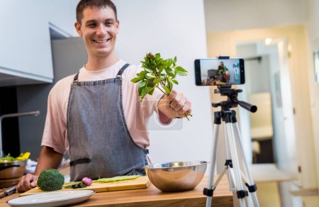 Foto de El chef está transmitiendo en vivo desde el taller cómo preparar un curry verde vegetariano. - Imagen libre de derechos