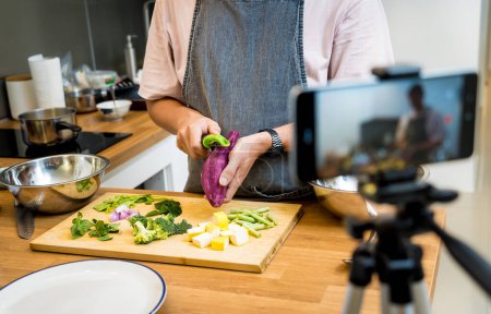 Foto de El chef está transmitiendo en vivo desde el taller cómo preparar un curry verde vegetariano. - Imagen libre de derechos