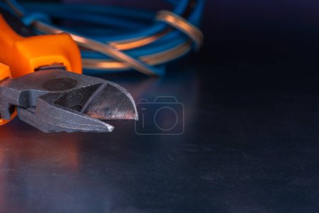 Photo for Cutting pliers and electrical cable close-up, electric workshop tool - Royalty Free Image