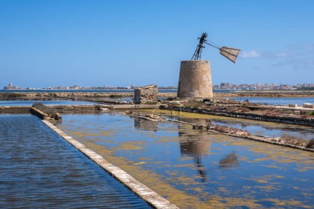 Old windmill and salt pans near Trapani at Sicily, Italy