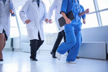 Téléchargez les photos : Image recadrée de médecins qui courent chercher de l'aide dans le hall de l'hôpital - en image libre de droit