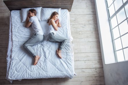 Téléchargez les photos : Vue du dessus de beau jeune couple dormant ensemble dans le lit à la maison - en image libre de droit