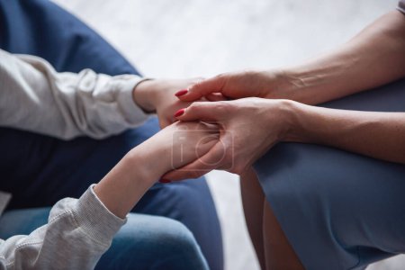 Photo for Teenage girl at the psychotherapist. Cropped image of doctor holding girl's hands - Royalty Free Image