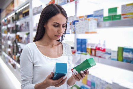 Beautiful young woman is choosing a medication at the pharmacy