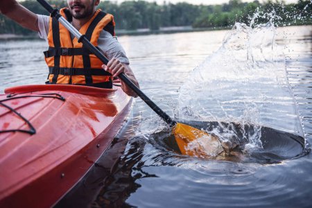 Téléchargez les photos : Image recadrée d'un beau jeune homme en gilet de mer naviguant en kayak - en image libre de droit
