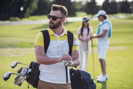 Foto de La gente hermosa está descansando y jugando golf, chico guapo en primer plano - Imagen libre de derechos