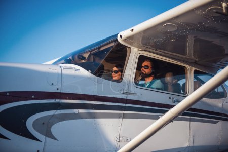 Foto de Hermosa pareja en auriculares de aviación está sentado en aviones listos para volar - Imagen libre de derechos