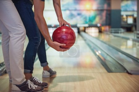 Photo for Cropped image of beautiful girl and handsome guy holding a bowling ball while playing - Royalty Free Image
