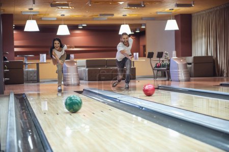 Photo for Happy young friends are having fun while playing bowling together - Royalty Free Image