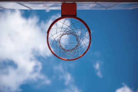 Téléchargez les photos : Vue du bas du panier de basket sur fond de ciel bleu - en image libre de droit