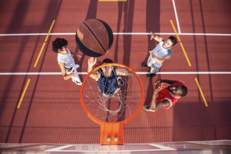 Téléchargez les photos : Vue du dessus des beaux joueurs de basket-ball jouant sur le terrain de basket en plein air - en image libre de droit