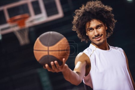 Photo for Attractive basketball player is playing basketball outdoors in the evening - Royalty Free Image