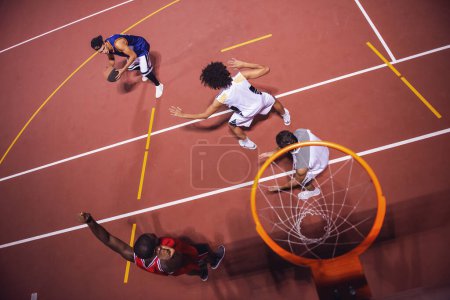 Photo for High angle view of handsome guys playing basketball outdoors at night - Royalty Free Image