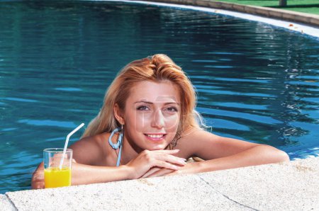 Foto de Mujeres bebiendo cóctel en la piscina. Retrato de hermosas mujeres jóvenes bebiendo cóctel en la piscina - Imagen libre de derechos