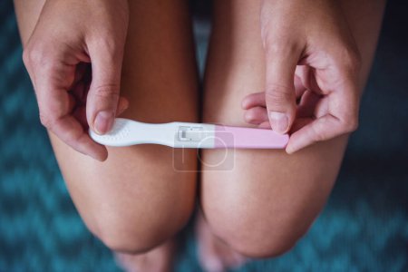 Téléchargez les photos : Image recadrée d'une femme tenant un test de grossesse à genoux - en image libre de droit