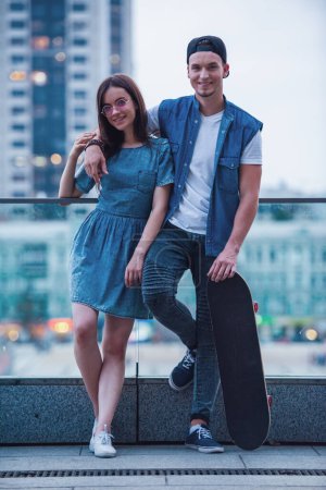 Téléchargez les photos : Élégant jeune couple est câlin, parler et sourire tout en marchant dans la ville - en image libre de droit