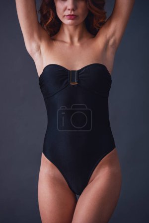 Téléchargez les photos : Portrait d'une jeune belle fille sexy en maillot de bain sur fond noir - en image libre de droit