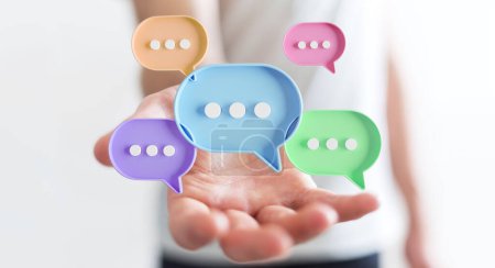 Photo for Businessman using digital colorful speech bubbles talk icons. Minimal conversation or social media messages floating over user hand. 3D rendering - Royalty Free Image