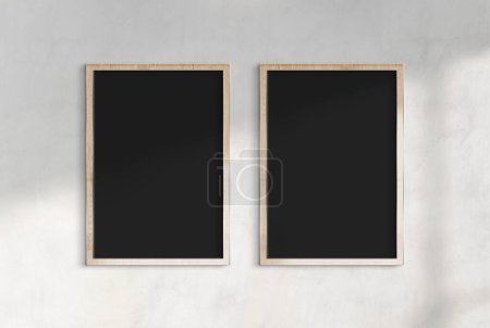 Foto de Dos carteles de madera colgados en una maqueta de pared de hormigón iluminada por el sol. Plantilla de marcos bañados por la luz solar 3D renderizado - Imagen libre de derechos