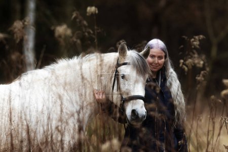 Téléchargez les photos : Femme aux cheveux blancs et cheval blanc sont dans la forêt - en image libre de droit