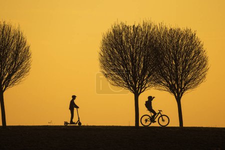 Photo for Black silhouettes sporting people against the colourful background of the setting sun - Royalty Free Image