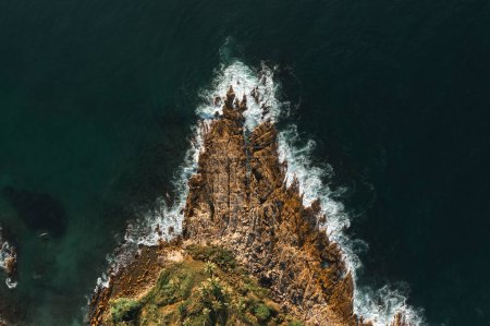 Téléchargez les photos : Vue aérienne de haut en bas du littoral de grandes vagues s'écrasant sur une falaise rocheuse. Belle surface de la mer sombre au coucher du soleil. Incroyable vue sur la mer. Photo de drone de haute qualité - en image libre de droit