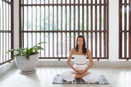 Téléchargez les photos : Méditation sportive de femme de yoga en pose de lotus à l'intérieur. Chemin vers la santé mentale et physique. Photo de haute qualité - en image libre de droit
