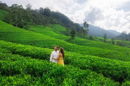 Foto de Naturaleza fondo plantaciones de té paisaje con una pareja romántica de viajeros enamorados de pie en contra de abrazar y mirar hacia otro lado - Imagen libre de derechos