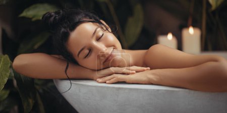 Photo for Home spa relax of bathing beauty woman resting in bathtub with closed eyes. Close-up portrait of attractive millennial woman relaxing in modern bathroom interior, happy lady enjoying taking hot bath - Royalty Free Image