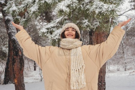 Téléchargez les photos : Profitez du temps d'hiver givré neigeux de la jeune femme dans la forêt de jour. Photo de haute qualité - en image libre de droit