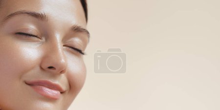 Photo for Skincare beauty spa face of woman with healthy skin, natural makeup .Young adult happy girl model with closed eyes on beige background extreme closeup. - Royalty Free Image