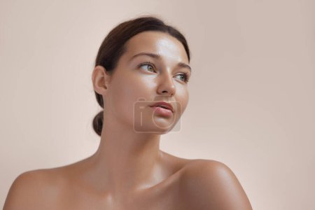 Photo for Skincare Beauty Spa Face of Woman with Healthy Skin, Natural Makeup .Young adult happy girl model with bare shoulders on beige background closeup. High-quality beauty product or treatment conceptual - Royalty Free Image