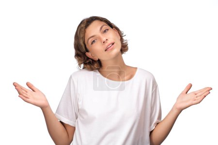 Photo for Shrugging woman in doubt doing shrug, attractive confused girl gesturing do not know sign on white background. High quality photo - Royalty Free Image