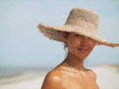 Beach sun hat woman on vacation. Close-up of a girls face in straw sunhat enjoying the sun looking at the camera. Stickers #706878348