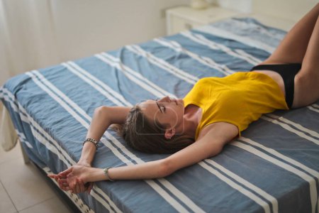 Photo for Portrait of young woman lying on the bed - Royalty Free Image