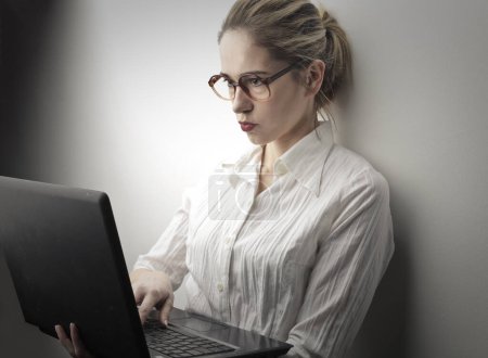 Téléchargez les photos : Inquiet jeune femme travaille sur l'ordinateur - en image libre de droit
