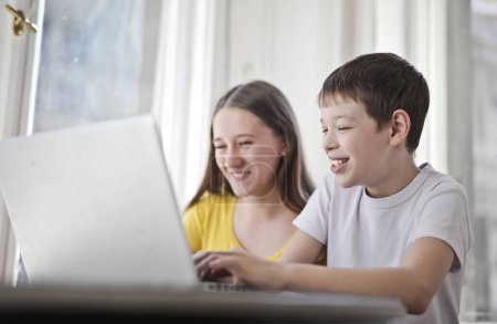 Foto de Hermano y hermana usan una computadora en casa - Imagen libre de derechos
