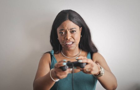 Photo for Woman with agitated expression plays video games, - Royalty Free Image