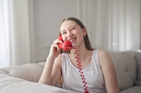 Photo for Young girl speaks laughing on the phone - Royalty Free Image