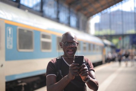 Foto de Hombre adulto en la estación de tren listo para salir se toma una selfie - Imagen libre de derechos