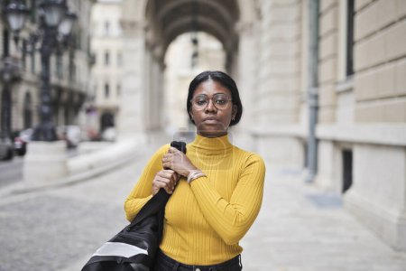 Foto de Negro mujer adulta en la calle con bolsa de gimnasio en el hombro - Imagen libre de derechos