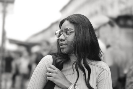 Foto de Negro mujer adulta en la calle con mochila en el hombro - Imagen libre de derechos